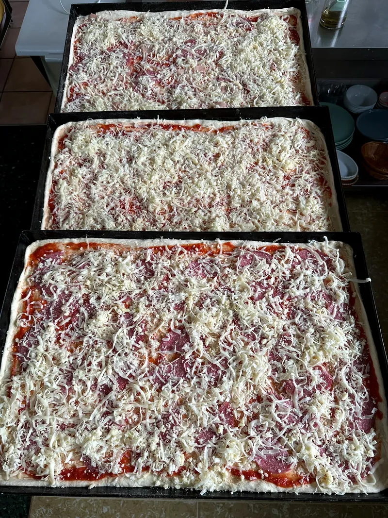 Frisch belegte Blechpizzen bereit für den Ofen