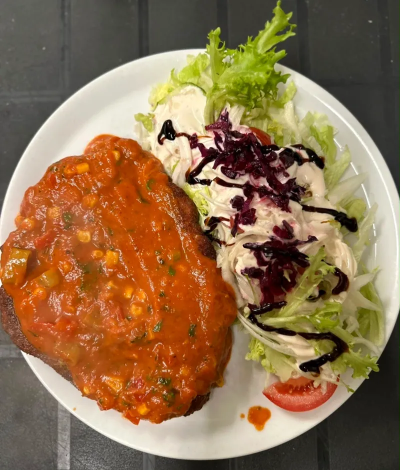 Herzhaftes Gericht mit frischem Salat auf weißem Teller